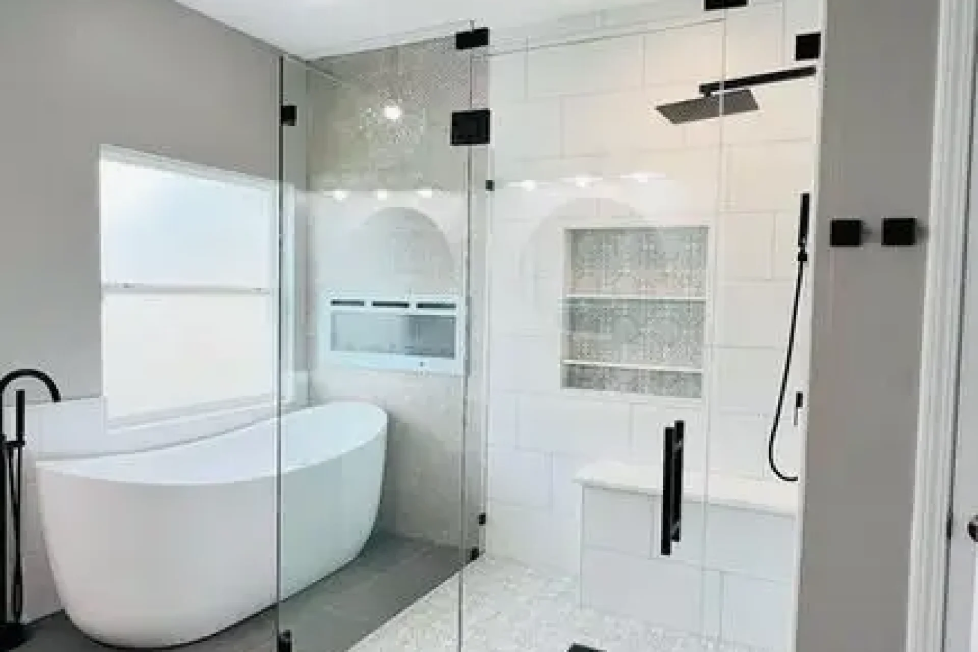 Spa-style bathroom with walk-in shower, black fixtures, and freestanding tub by GIL Renovation Services in North Florida.
